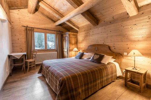 拉克吕萨La Ferme du Var的木制客房内的一间卧室,配有一张床