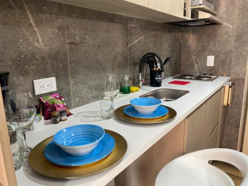 波哥大Beautiful Loft 35 Movistar Arena - Campin - Chapinero Bogota Colombia HOSTMI的厨房柜台配有2个蓝色碗和水槽