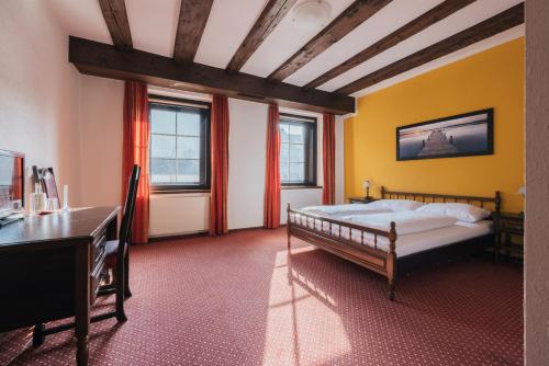 费尔德基希Hotel Bären的卧室配有一张床、一张书桌和窗户。