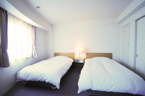 稚内萨哈林酒店的两张睡床彼此相邻,位于一个房间里