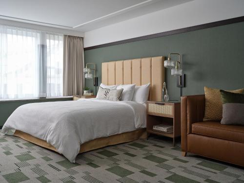 汉诺威六南街酒店的一间卧室配有一张大床和一把椅子