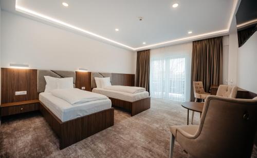 ScheiaHotel Ariata的酒店客房配有两张床和一张书桌