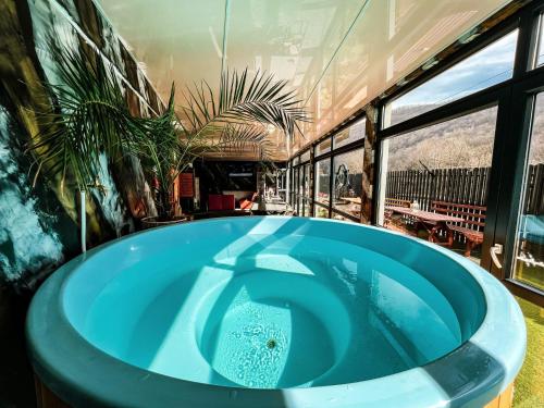 Someşu ReceTRANSILVANIA BLISS COTTAGE的窗户客房内的大蓝色浴缸