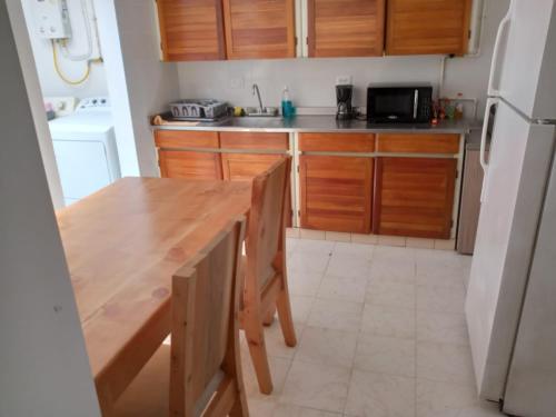 麦德林Road Living Home的厨房配有木桌和冰箱。