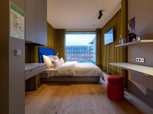 杜塞尔多夫b'mine hotel Düsseldorf的一间卧室设有一张床和一个大窗户