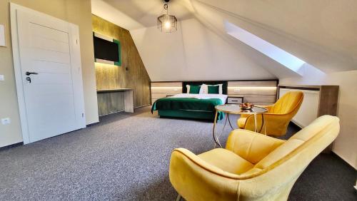 锡比乌Loft by Lumiere Sibiu的酒店客房带一张床、一张桌子和椅子