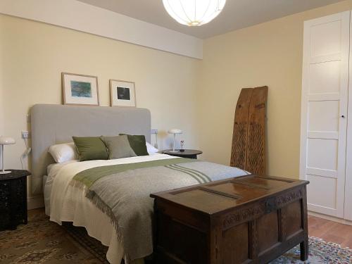 RameltonRiverfront Apartments at The Blue Goat Ramelton的一间卧室配有一张大床和木桌
