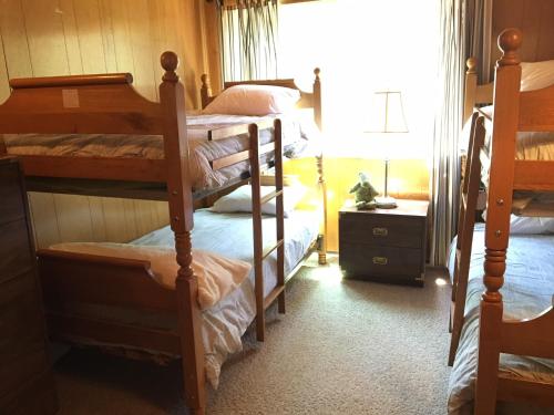玛瑙湾Classic Carnelian Bay Log Cabin的一间卧室设有三张双层床和一扇窗户。