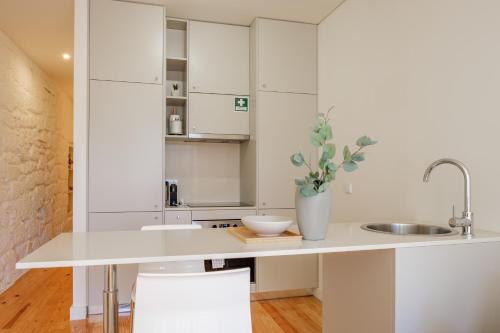 波尔图AgapeStay Porto的厨房配有白色橱柜和水槽