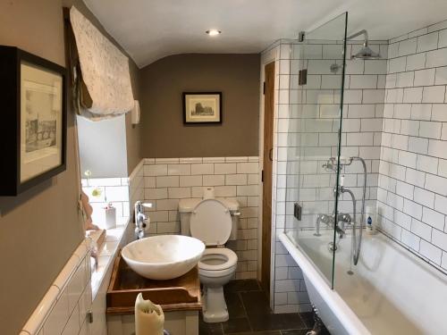 韦瑟比Garden Cottage的浴室配有盥洗盆、卫生间和浴缸。