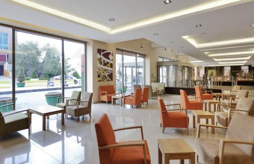 安曼ibis Amman的餐厅设有橙色椅子和桌子以及窗户。