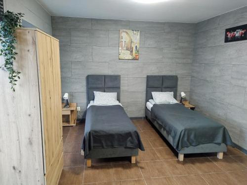 普沃茨克Hotel Apartamenty 72的配有2张单人床的带墙壁客房