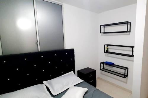 库库塔Apartamento en Cúcuta completó en condominio 19的一间卧室配有一张带黑色床头板的床