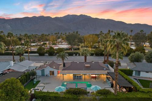 棕榈泉The Ritz - Luxury Home with Pool & Speakeasy Bar的享有棕榈树和山脉房屋的空中景致