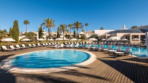卡武埃鲁Vale d'Oliveiras Quinta Resort & Spa的度假村内带椅子和遮阳伞的游泳池
