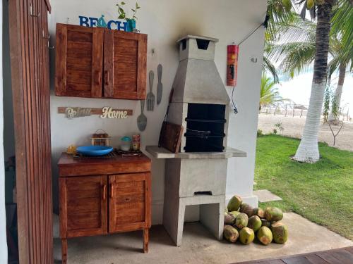 BarroquinhaBeira-mar Chácara Curimãs - Barroquinha, Ceará的厨房配有烤箱和带水果的桌子。