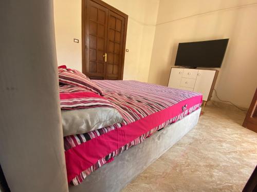 开罗Comfy private room with big sunny balcony near cairo airport مكان مودرن للاقامة دقائق من مطار القاهرة الدولى的一间卧室配有一张带粉色毯子的床