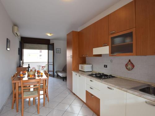 洛萨皮内塔Apartment Acquamarina-3 by Interhome的厨房配有桌子和炉灶。 顶部烤箱