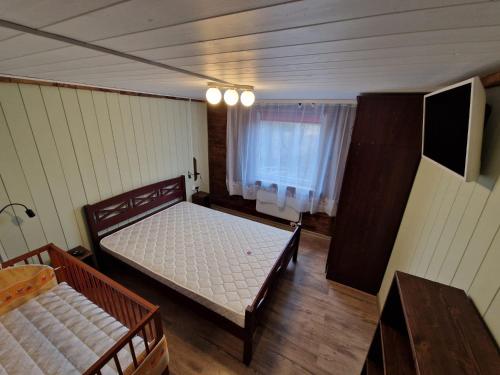 IlūksteIlūkstes Sauna apartamenti (bezkontakta)的一间卧室配有两张床和电视。
