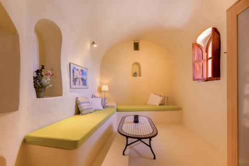 Éxo GoniáCharming Restored 300yr-0ld Guest House的一间设有两张绿色长椅和一张桌子的房间