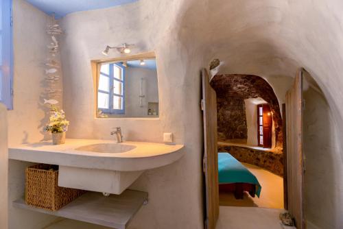 Éxo GoniáCharming Restored 300yr-0ld Guest House的一间带水槽和镜子的浴室以及一张床