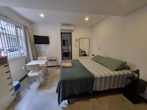 里约热内卢Suítes/Studios Privados Copacabana的一间卧室配有一张床、一张桌子和一张书桌