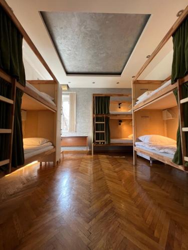 贝尔格莱德Cabbage Hostel的客房设有两张双层床,铺有木地板。