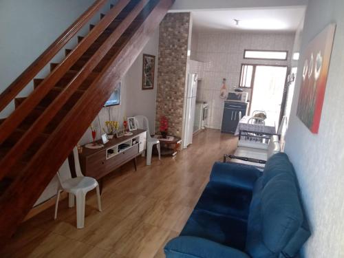 卡波布里奥Meu Aconchego的客厅设有蓝色的沙发和楼梯。