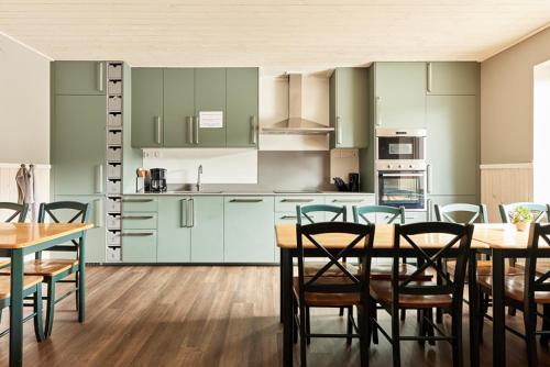 Gustavsfors阿尔卡特拉斯酒店的厨房配有绿色橱柜和桌椅