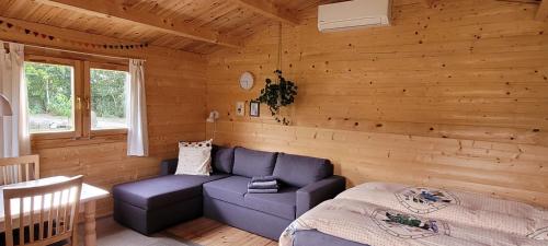 BækkeAgnes Bed and Breakfast的小木屋内的客厅配有蓝色沙发