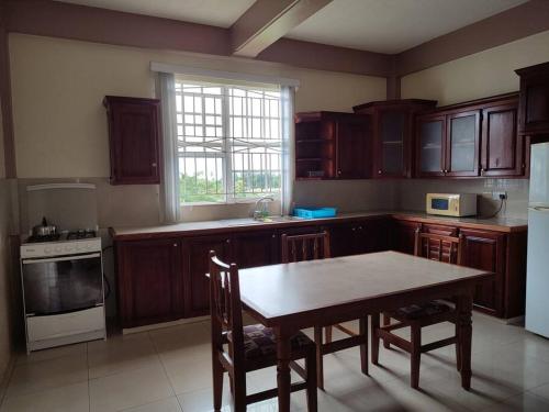 PortsmouthIso’s Vacation Rental Apartment #10的厨房配有木制橱柜、桌子和窗户。