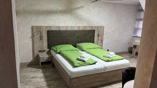 索尔陶吾王酒店 的一间卧室配有一张带绿床单和枕头的床。
