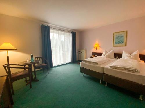 Lubast鲁巴斯特希斯酒店的酒店客房设有两张床、一张桌子和一个窗户。