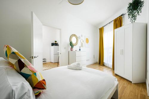 布里斯托Charming 1 bedroom apartment (+ sofa bed) in Central Bristol的白色卧室配有床和镜子