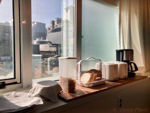首尔ARA125的厨房柜台设有窗户,配有面包和家电