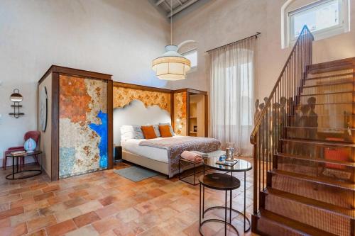 莱切Palazzo Maresgallo Suites & SPA的一间卧室设有一张床,楼梯设有楼梯。