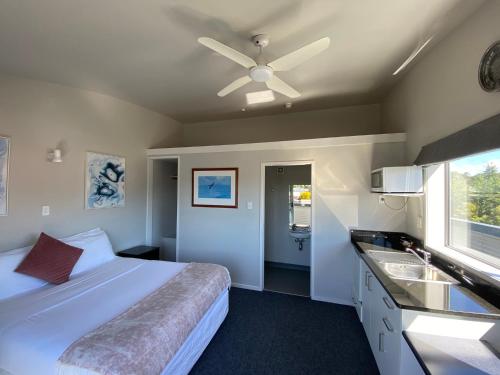奥阿库尼LKNZ Lodge & Cafe的一间卧室配有一张带吊扇和水槽的床。