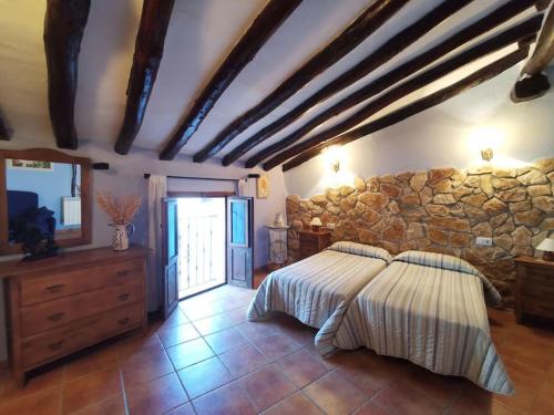 MontalbánCasa Roya的一间卧室设有一张床和石墙