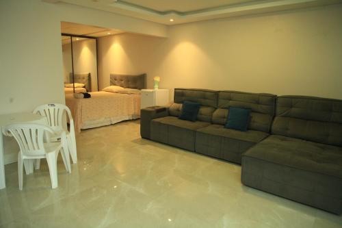 弗洛里亚诺波利斯Valentina 24 HORAS的客厅配有沙发、桌子和床。
