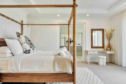 LochinvarLuxury Hunter Valley Estate的一间卧室配有天蓬床和镜子