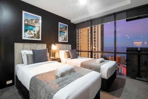 黄金海岸Circle on Cavill - Self Contained, Privately Managed Apartments的酒店客房设有两张床和大窗户。