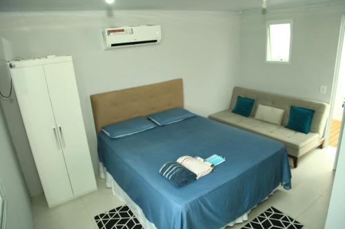 弗洛里亚诺波利斯Valentina 24 HORAS的一间卧室配有蓝色的床和沙发