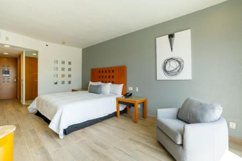 托雷翁Real Inn Torreon的卧室配有白色的床和椅子