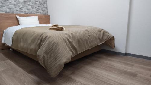 秩父市Basic Hotel Chichibu的床上有棕色毯子