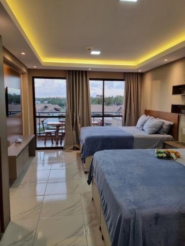 塔曼达雷FLAT 227 l Eco Resort - Praia dos Carneiros - Ao lado da Igrejinha的酒店客房设有两张床和一个阳台。