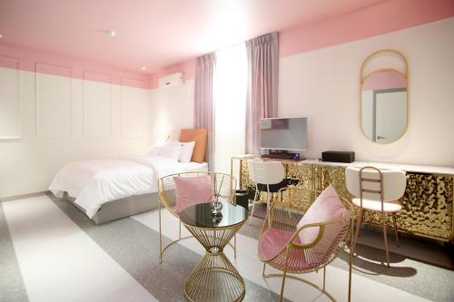 GimcheonBaba Hotel Gimcheon的酒店客房带床、椅子和镜子