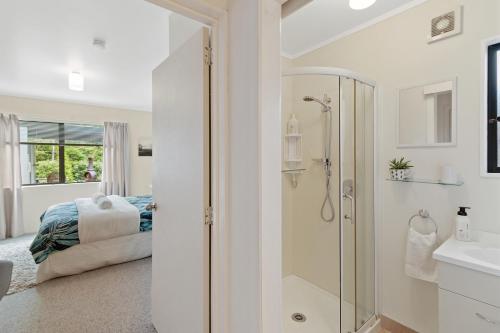 KarangahakeRiverside Accommodation的带淋浴的白色浴室和1张床