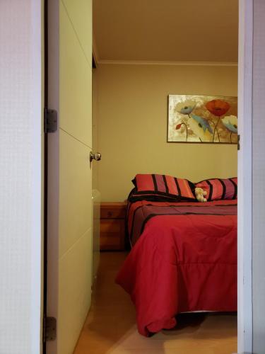 塔尔卡Departamento en Alameda Talca的一间卧室设有两张床,墙上挂着一幅画