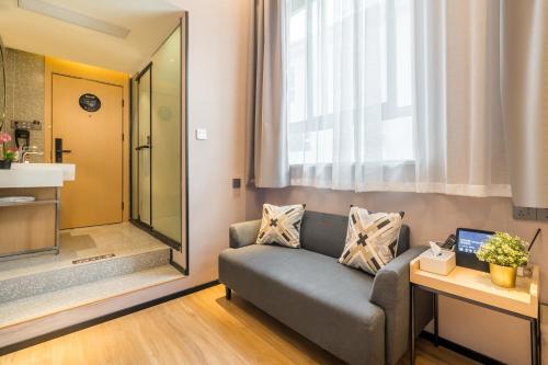 上海上海Meego米果智选酒店(西康路店)的带沙发和镜子的客厅