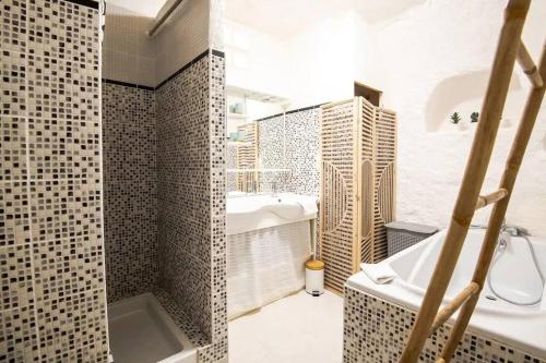 吕讷Maison troglodyte - Le Cerisier Perché的带浴缸、水槽和浴缸的浴室